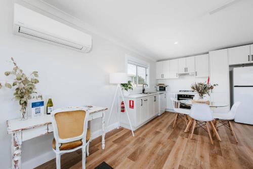 a kitchen with white cabinets and a table and chairs at Joseph's Place - A Restful Retreat for Two in Mudgee