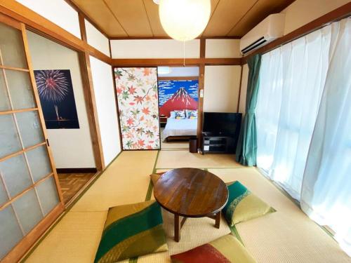 a living room with a table and a bed at Nostalgic Jpn Drct to Shinjuku JR Sta in Tokyo