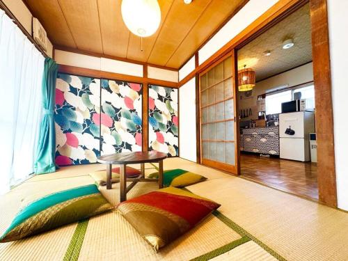 a room with a table and pillows on the floor at Nostalgic Jpn Drct to Shinjuku JR Sta in Tokyo