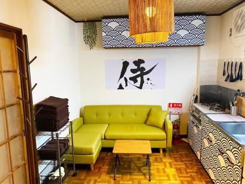 a living room with a green couch and a table at Nostalgic Jpn Drct to Shinjuku JR Sta in Tokyo