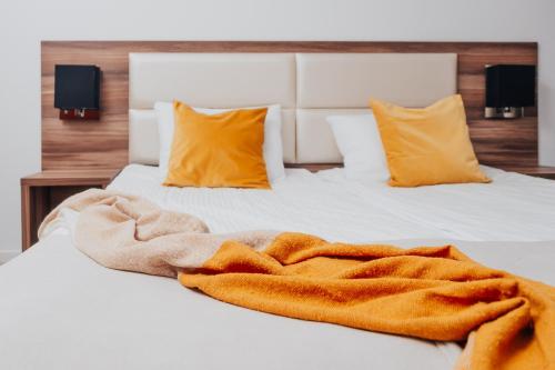 a blanket laying on a bed with two pillows at Hotel Sphinx in Żabia Wola