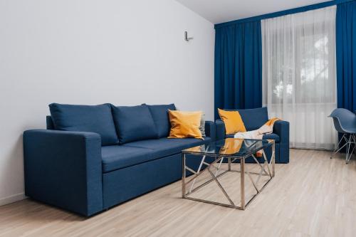 a blue couch and a glass table in a living room at Hotel Sphinx in Żabia Wola