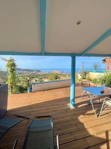 un patio avec une table, des chaises et un parasol dans l'établissement Superbe studio neuf vue mer, à Monticello