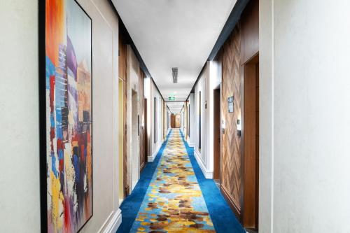 a hallway with colorful floors and art on the walls at Elaf Qinwan Hotel in Makkah