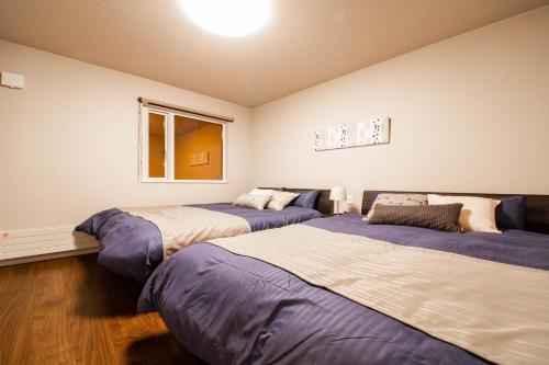 a bedroom with two beds and a window at THE SUN LOUNGE in Kushiro