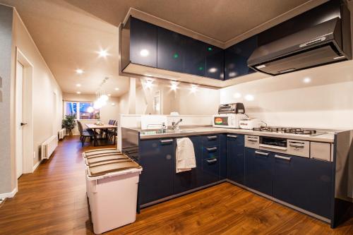 a large kitchen with blue cabinets and a table at THE SUN LOUNGE in Kushiro