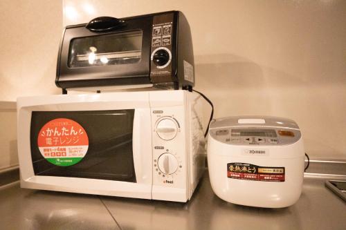 a microwave and a toaster oven on top of a counter at THE SUN LOUNGE in Kushiro