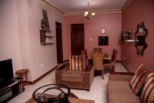 a living room with a couch and a table at SJA Furnitured Apartments in Kitende