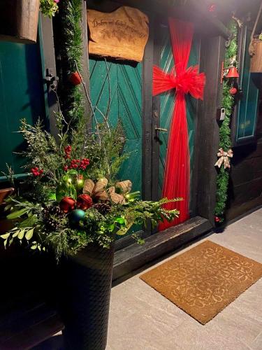 a vase filled with christmas decorations in front of a door at M&M Kuća za odmor in Vrbovec