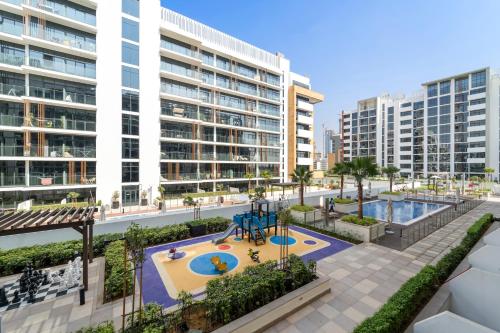 an apartment complex with a playground and buildings at Studio Azizi Riviera 28 Community View in Dubai