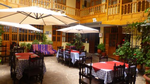un restaurante con mesas, sillas y sombrillas en Hospedaje Samana Wasi Pisac en Pisac