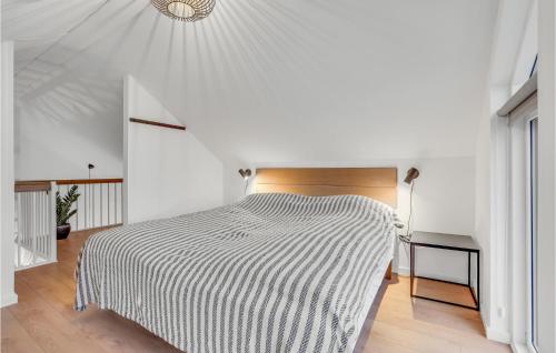 a bedroom with a bed with a black and white blanket at Havnehusene, Lejl 44 in Engvang