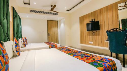 a hotel room with two beds and a tv at Hotel Global Inn in Amritsar