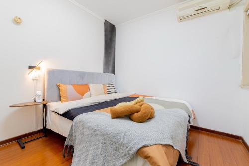 a bedroom with a bed with a teddy bear on it at Ban Xia Sunshine Hotel- Drum Tower & YONGNING Gate Branch in Xi'an