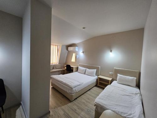 a small room with two beds and a window at Hotel Racic Self-Check In in Voyvodinovo