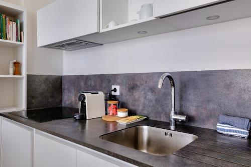 une cuisine avec un évier et un plan de travail dans l'établissement Appartement au coeur de la presqu'ile, à Lyon