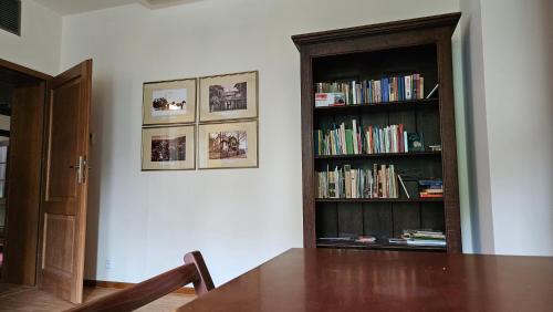 a room with a table and a book shelf with books at Jasny Dwór in Polanica-Zdrój