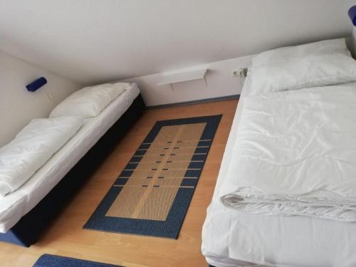 a small room with two beds and a rug at Ferienwohnung Wellenherz - Wohnung 9 in Breege