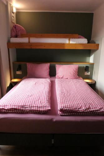 a bunk bed with pink and white checkered pillows at Haus Katris in Mauterndorf