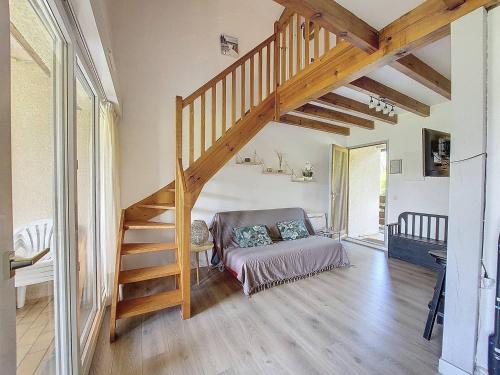 un salon avec un escalier et un canapé dans l'établissement S-Plage 01-Soustons Appartement pour 6 personnes en duplex proche lac marin, à Soustons