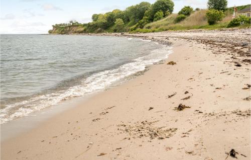 a beach with footprints in the sand next to the water at 4 Bedroom Amazing Home In Søby Ærø in Søby
