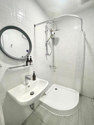 a white bathroom with a sink and a mirror at PJ Hostel & Bar in Pattaya