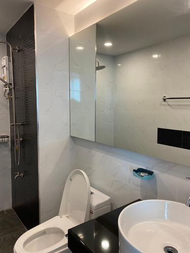 a bathroom with a white toilet and a sink at MAHIDOL CONDO มหิดลคอนโด in Chiang Mai