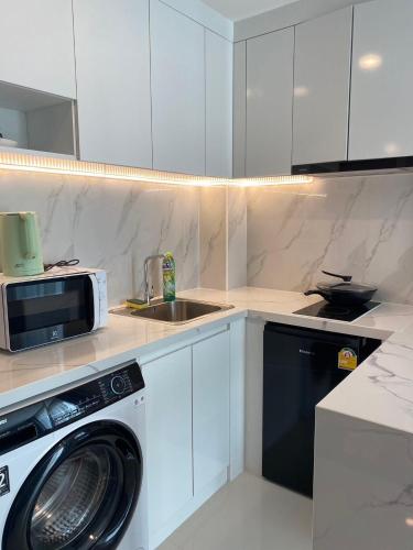 a kitchen with a washing machine and a sink at MAHIDOL CONDO มหิดลคอนโด in Chiang Mai
