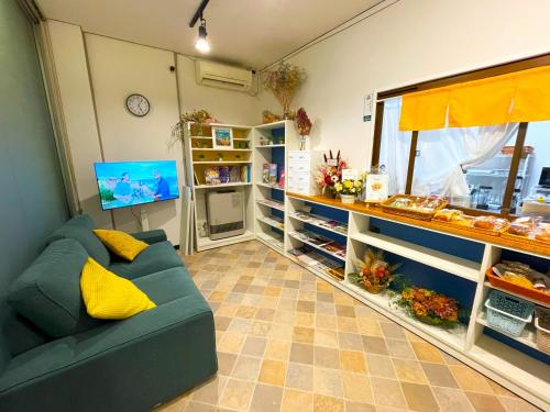a room with a couch and a counter with food at naka-yasumiゲストハウスなかやすみ in Aizuwakamatsu