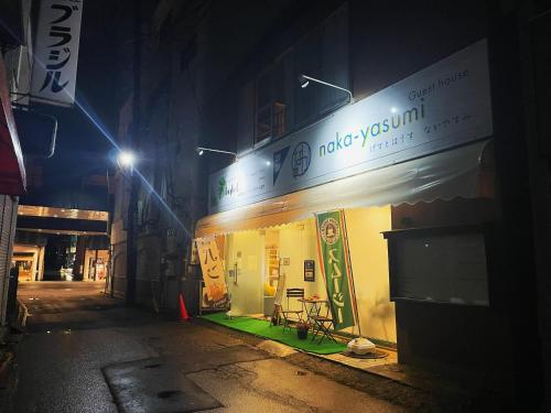 a building with a sign on the side of it at night at naka-yasumiゲストハウスなかやすみ in Aizuwakamatsu