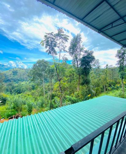 a view from the balcony of a house with a green roof at Cloudy Hill Cottage in Ella