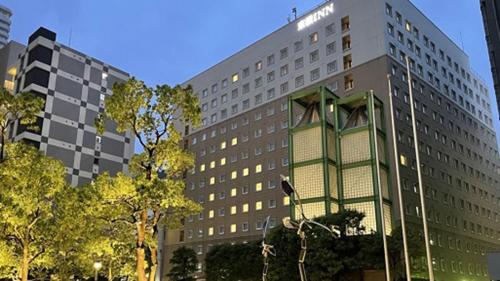 a large office building with a green building at Toyoko Inn Tokyo Shinagawa Konan-guchi Tennozu Isle in Tokyo