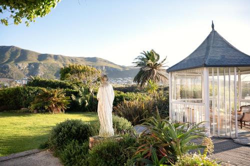 a statue of a woman in a garden with a gazebo at Kennedys Beach Villa in Hermanus