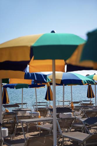 a bunch of chairs and umbrellas on a beach at Glamping Costa Smeralda in Baraccamenti