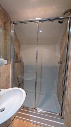 a bathroom with a shower and a sink at Charming Lake House nature retreat in Cotswold Water Park, South Cerney near Cirencester in Cirencester