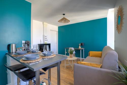 a blue living room with a table and a couch at La Girelle -4 pers- Balcon- parking gratuit in Bourg-en-Bresse