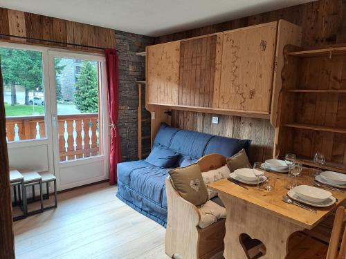 un salon avec un canapé bleu et une table dans l'établissement Appartement équipé centre Carroz et garage, à Arâches-la-Frasse