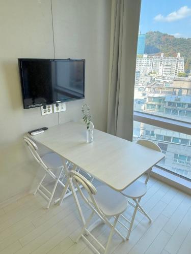 a white table and chairs in a room with a large window at Busan Seomyeon Residence in Busan