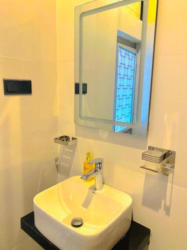 a bathroom with a white sink and a mirror at Cloudy Hill Cottage in Ella