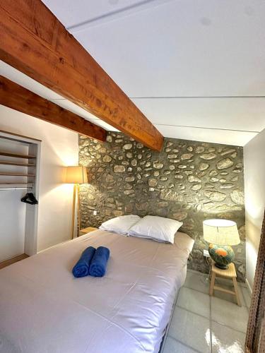 una camera da letto con un letto grande con un muro di pietra di Charmante maison de village ad Argelès-sur-Mer