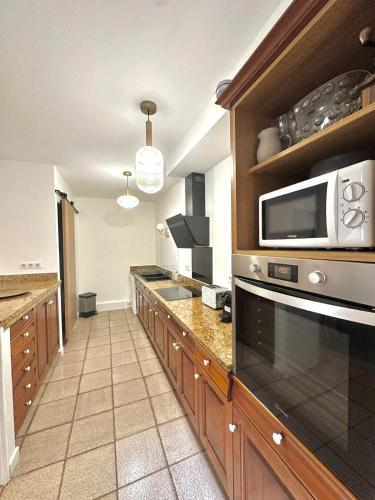 une cuisine avec un micro-ondes et un plan de travail dans l'établissement Charmante maison de village, à Argelès-sur-Mer