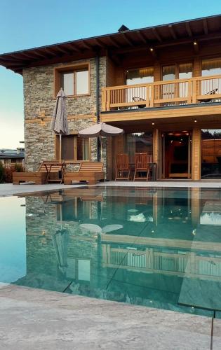a house with a swimming pool in front of it at Solis Thermal Villas- HOT pool in Banya