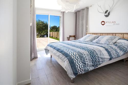 une chambre avec un lit avec une couette bleue et blanche dans l'établissement Villa bord de mer avec piscine 200 métres plage, à Zonza