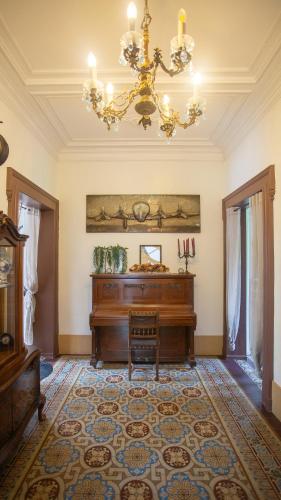 a room with a piano and a chandelier at Le Petit Chateau in Saint-Michel