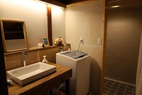 a bathroom with a sink and a toilet and a mirror at Solabase in Kazo