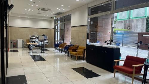 a lobby with chairs and tables in a building at Toyoko Inn Tokyo Shinagawa Konan-guchi Tennozu Isle in Tokyo