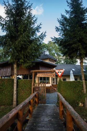 a wooden walkway leading to a house with a building at Penzion za mlynom in Bešeňová
