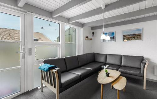 a living room with a black couch and a table at Nice Apartment In Hemmet With Sauna in Hemmet