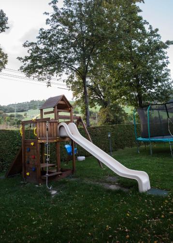 a playground with a slide in the grass at Penzion za mlynom in Bešeňová