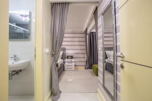 a bathroom with a sink and a mirror at Guest House Benedict in Split